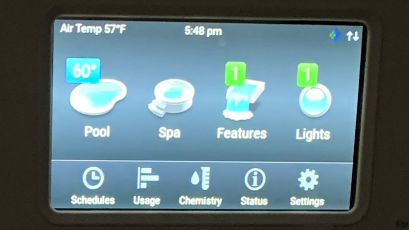 Pentair Intelliflo control panel display with top of screen showing Air Temp 57F, 5:48 pm, and icons labeled Pool, Spa, Features, Lights, Schedules, Usage, Chemistry, Status, Settings