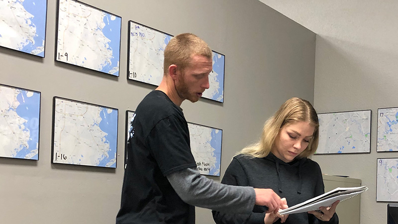 Justin and Leah going over route changes in The Pool Boys office